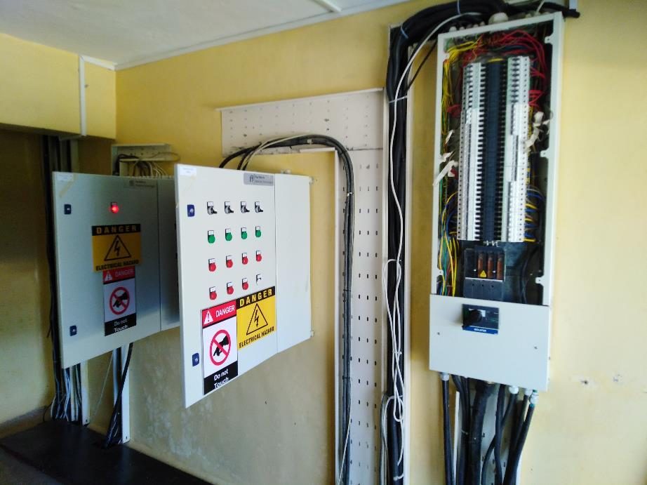 Completed electrical panel installation with hazard warning labels